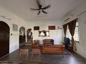 a living room with a ceiling fan and chairs at Mawar 23 Chendering with Private Pool in Kuala Terengganu