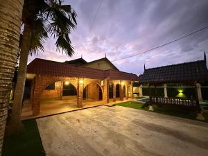 una casa con un patio con una palmera en Mawar 23 Chendering with Private Pool en Kuala Terengganu