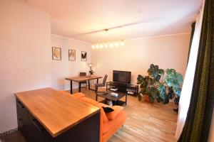 ein Wohnzimmer mit einem orangenen Sofa und einem Tisch in der Unterkunft Apartamenty Basztowa in Świdnica