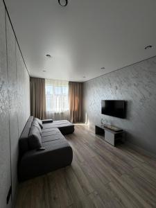 un salon avec un canapé et une télévision à écran plat dans l'établissement Шикарная квартира в центре! Делаем документы!, à Aktau