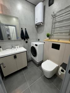 une salle de bain avec un lavabo et une machine à laver dans l'établissement Шикарная квартира в центре! Делаем документы!, à Aktau