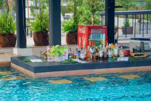 a table with bottles and drinks on top of a swimming pool at Sunbeam Hotel Pattaya in Pattaya