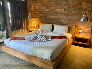 een slaapkamer met een bed met twee zwanen erop bij Unotel Karon Beach in Karon Beach