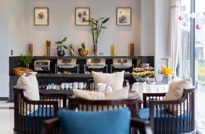 ホイアンにあるEco Lux Riverside Hotel & Spaのテーブルと椅子のあるレストラン、ビュッフェ