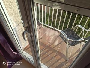 a chair sitting on a balcony looking out a window at Hostal Galicia in Figueres
