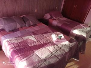 two beds in a bedroom with a purple comforter at Hostal Galicia in Figueres