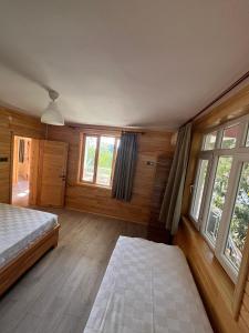 a bedroom with two beds and two windows at Lemon Garden Lodge in Cıralı