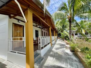 a porch of a house with palm trees at Airis Sanctuary Resort in Pantai Cenang