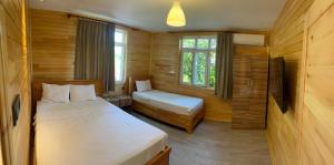 a small room with two beds and a window at Lemon Garden Lodge in Cıralı