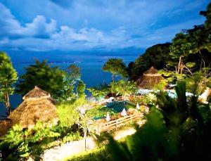 俊島的住宿－裕姆島度假村，一个带游泳池和稻草遮阳伞的度假村