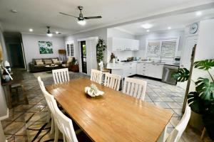 uma cozinha e sala de estar com uma mesa de madeira e cadeiras em Ally’s Umina Oasis, pet-friendly spa coastal oasis em Umina