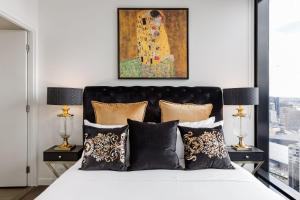 Un dormitorio con una cama con un cuadro en la pared. en VAQUAY Luxor In Southbank, en Melbourne