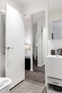 Un baño con inodoro, lavabo y espejo. en VAQUAY Luxor In Southbank, en Melbourne