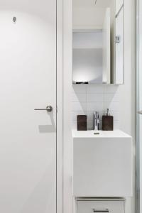 Un baño blanco con lavabo y espejo. en VAQUAY Luxor In Southbank, en Melbourne 26 fotos más