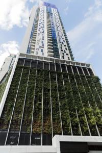 Un edificio alto con plantas en la fachada. en VAQUAY Luxor In Southbank, en Melbourne