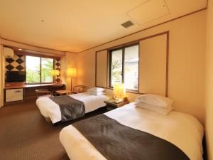 諏訪市にある信州上諏訪温泉 浜の湯のベッド2台とテレビが備わるホテルルームです。