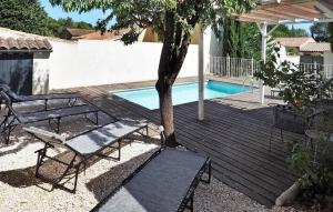eine Holzterrasse mit einem Tisch und einer Bank neben einem Pool in der Unterkunft La Villa De Maussane in Maussane-les-Alpilles