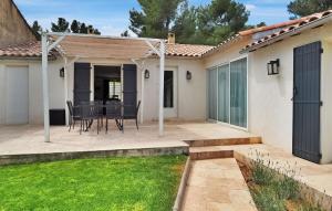 eine Terrasse mit Tisch und Stühlen in einem Hof in der Unterkunft La Villa De Maussane in Maussane-les-Alpilles