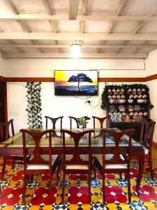 VandiperiyārにあるBunk Club Hostelのテーブルと椅子とテレビのあるダイニングルーム