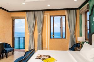 a bedroom with a bed and a view of the ocean at Hoàng Hôn Tím Boutique Hotel in Phú Quốc