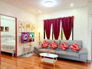a living room with a couch and red pillows at Secluded Apartment with Full Kitchen & Balcony Garden View in Liloan