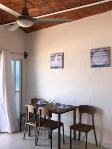 LA PUCCA HOTEL BOUTIQUE RESORT في بينيتا دي جالتيمبا: طاولة طعام مع كراسي وسقف