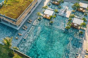 - une vue aérienne sur une piscine d'eau bordée de palmiers dans l'établissement The Victoria Resort Sam Son, à Sầm Sơn