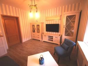 a living room with a tv and a chair at Holiday apartment Gitti Ueckermünde in Ueckermünde