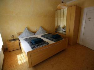 Un dormitorio con una cama con almohadas azules y un espejo. en House Neeltje, Apartment 3, en Borkum