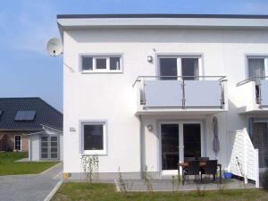 a white house with a table in front of it at Tacke 2 Comfortable holiday residence in Burg auf Fehmarn