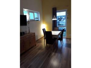 a dining room with a table and chairs and a television at Tacke 2 Comfortable holiday residence in Burg auf Fehmarn