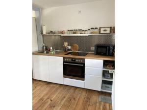 a kitchen with white cabinets and a stove top oven at Haus FeLiSi Comfortable holiday residence in Bad Grund
