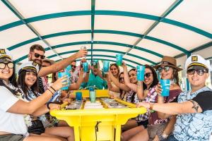un grupo de personas sentadas alrededor de una mesa con bebidas en Mango-Women Dorms - Men Dorms - Free Laundry-WiFi-Parking-Bbq en Fort Lauderdale