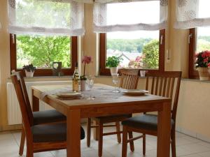 een eettafel met stoelen en een fles wijn bij Basche Comfortable holiday residence in Oberzissen