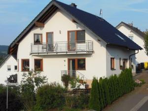 een wit huis met een zwart dak bij Basche Comfortable holiday residence in Oberzissen