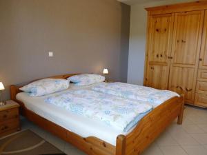 een slaapkamer met een houten bed met 2 kussens bij Basche Comfortable holiday residence in Oberzissen
