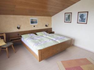 a bedroom with a bed and a chair at Haus Fernblick Apartment 2 in Bad König +26 photos