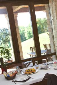 a table with plates of food on it in front of windows at Agriturismo La Spiga D'Oro in Frontino