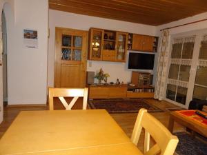 a living room with a table and a tv at Anna Geißinger Comfortable holiday residence in Mauth