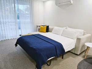 a bedroom with a bed with a blue blanket on it at Kashmir, Modern and luxury 2BR 2BA, Fast WiFi & Netflix, Free Parking, Central Location, near CBD in Canberra