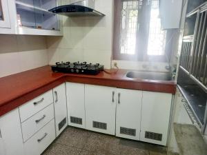 uma cozinha com armários brancos e um lavatório em Garden View Residency, Deluxe Queen Room 1 em Lucknow