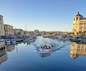 a group of people in a boat in a harbor at Appartamento Dammuso Isola Di Ortigia in Siracusa