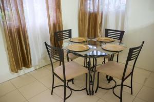 a dining room table with four chairs and a table and chairsktop at Clauds Place in Rodney Bay Village