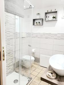 y baño con ducha, aseo y lavamanos. en Appartamento Dammuso Isola Di Ortigia en Siracusa