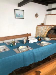 a table with a blue table cloth and a fireplace at Вила Стела in Sinemorets