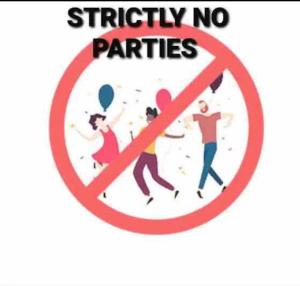 a sign with people running in a circle with the words strictly no parties at Home Stay in Mumbai