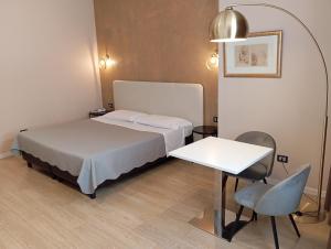 a bedroom with a bed and a table and a chair at Relais Peucetia in Gravina in Puglia
