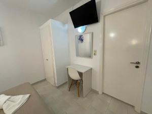 Pokój z biurkiem i telewizorem na ścianie w obiekcie ANCHOR w mieście Provatas