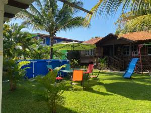 einen Garten mit einem Tisch und Stühlen sowie einem Spielplatz in der Unterkunft Hermosa Cabaña en Marbella!Omoa, Cortès in Omoa