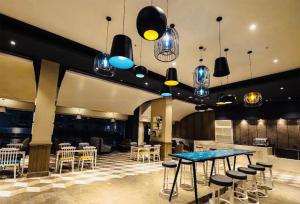 - un hall avec une table, des chaises et des lumières dans l'établissement Country Inn & Suites, à Lucknow